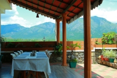 Elegant dining table setup with fine cutlery and a view of the natural surroundings at Nest Inn Resort.