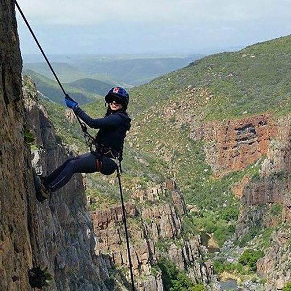 Professional instructor providing guidance and assistance to a climber during a rock climbing session at the resort.